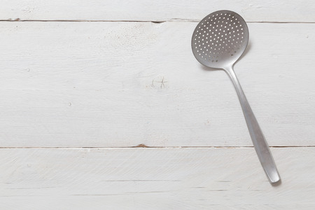 slotted spoon on rustic wood background in bird's eye view.の写真素材