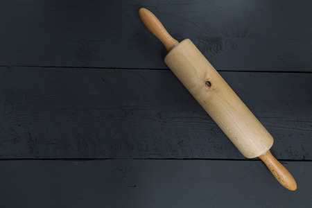 Rolling pin on a black wood as the background.の写真素材
