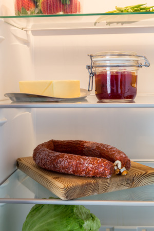 Open fridge stuffed with salami and food stuffs.の写真素材