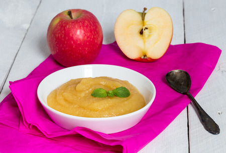 Applesauce on pink paper and spoonの写真素材