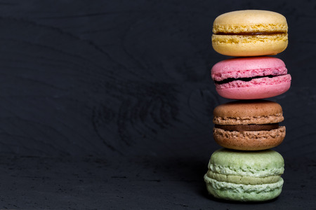 Colorful macarons on a black wood.の写真素材