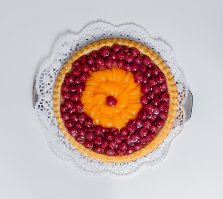 Fruitscake with cherries and mandarin on white background.の写真素材