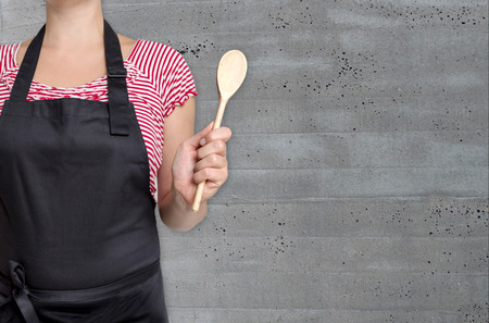concept template cook holding wooden spoon with concrete structure.の写真素材
