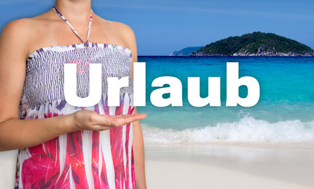 Urlaub (in german Holiday) concept is presented by woman on the beach.の写真素材