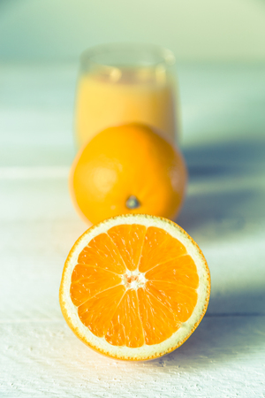 Orange juice in glass and orange on wooden table.の写真素材