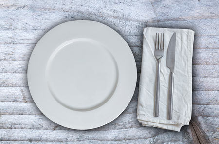 Empty plate with silverware on gray background.の写真素材