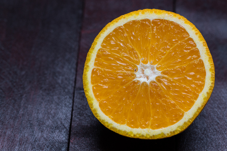 Orange sliced on mahogany wood background.の写真素材