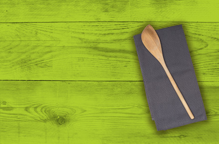 Wooden spoon and kitchen towel on green wood.の写真素材