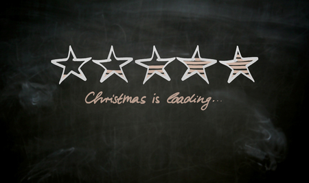 Christmas is loading concept painted on blackboard.