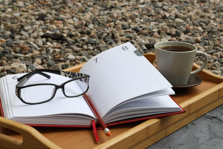 Pen with a business notebook on a wooden table background and glasses for vision