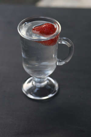 fresh juicy strawberries in a glass of mineral water. Cooling summer drink