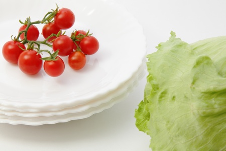 Cherry tomatoes and iceberg lettuce isolated on white backgroundの写真素材