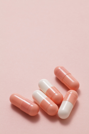 Pink pills on pink background