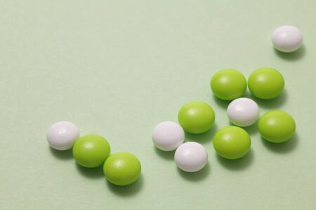 Green and white pills on green backgroundの写真素材