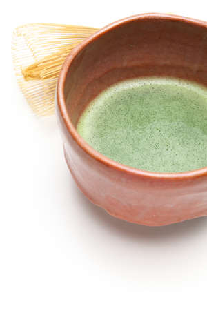 Japanese matcha tea in a bowl and tea whisk on white backgroundの写真素材