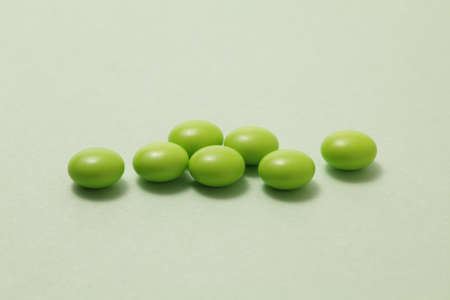 Green pills on green backgroundの写真素材