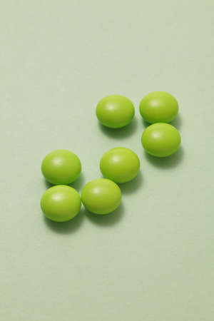 Green pills on green backgroundの写真素材