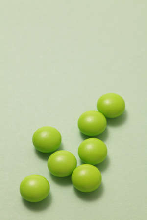 Green pills on green backgroundの写真素材