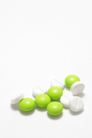 Green and white pills on a white background.の写真素材
