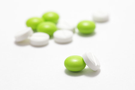Green and white pills on a white background.の写真素材