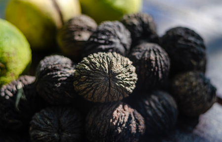 Black figs on a wooden table. Close-up. Selective focus.