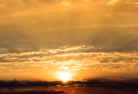 Orange sun ray light from sundown with overcast skyの写真素材