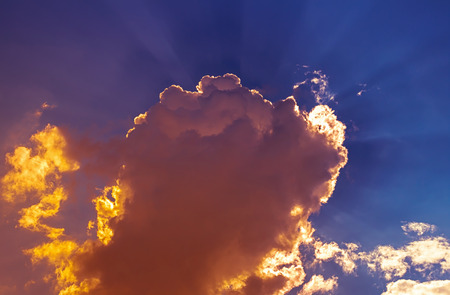Orange flame clouds in dark blue sky