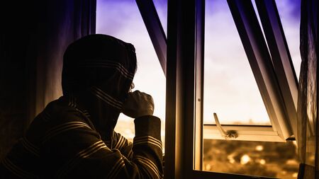 sad man sit near the windowの写真素材