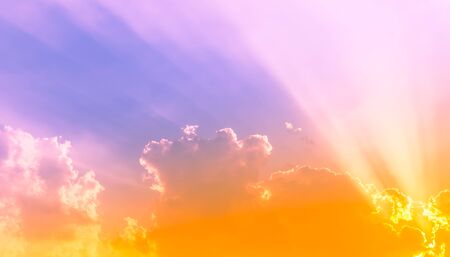 orange sunset light with yellow light on purple sky and sun beam