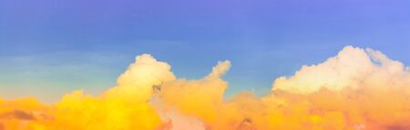 airplane on panorama blue purple sky with bright yellow on cloudsの写真素材