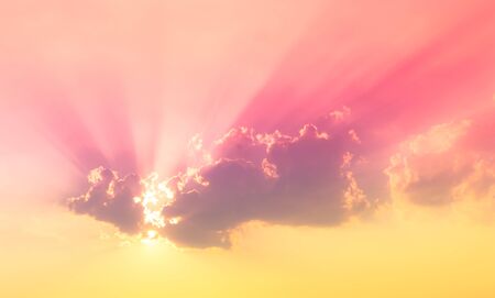 red pink and yellow color in sky with sun beam light and cloudsの写真素材
