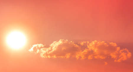 hot sun bright in red orange sky with cloudsの写真素材