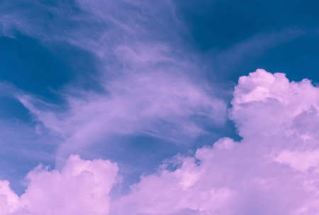dim pink clouds in overcast blue skyの写真素材