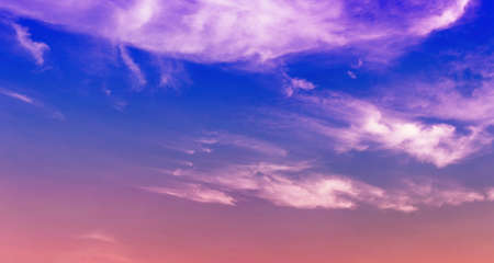 purple and pink light in twilight blue sky with soft cloudsの写真素材