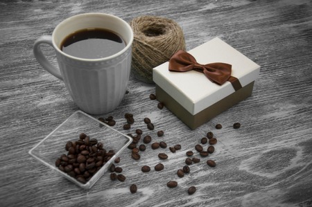 hank of threads, gift box, coffee beans and cup of cofee on grayの写真素材