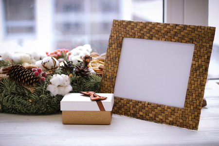 Desktop photo frame, christmas wreath and gift box on white sillの写真素材