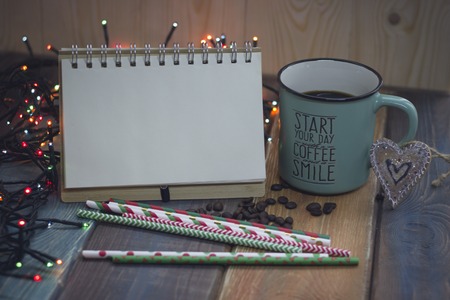 Notepad, blue cup and sweet sticks on a wooden tableの写真素材