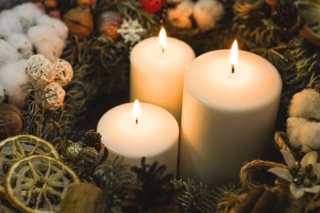 White burning christmas candles in a christmas wreathの写真素材