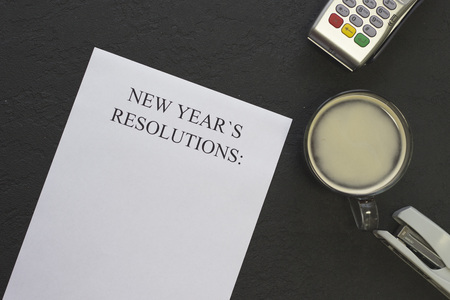 New Years resolutions paper,a cup of coffee with foam on a black background