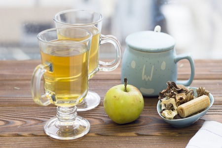 Two glass tea cups,an apple, sugar bowl and a cookieの写真素材