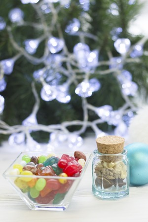 A bowl of candies, a jar of dry flowers and a Christmmas-tree ballの写真素材