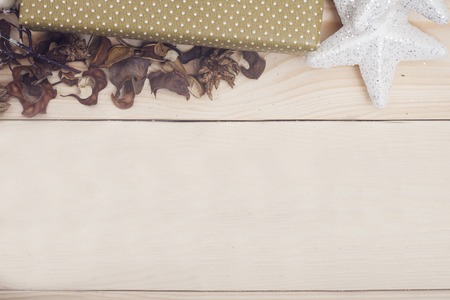A wooden Christmas background with a side of a gift box and a toy starの写真素材