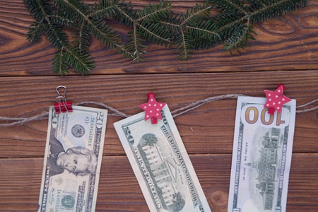 Christmas rustic wooden background with fir tree branches and dollar bills