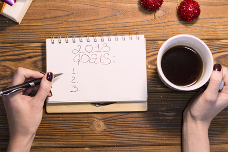 2018 goals inscription in a notebook, hands holding a coffeeの写真素材