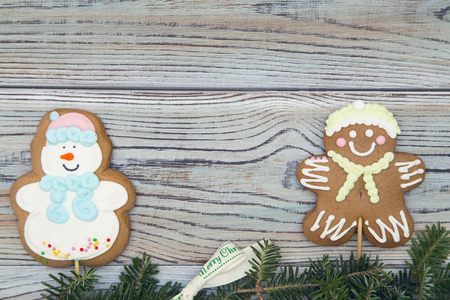 Light wooden shabby background for Christmas or New Year with a ginger bread cookies on each side...