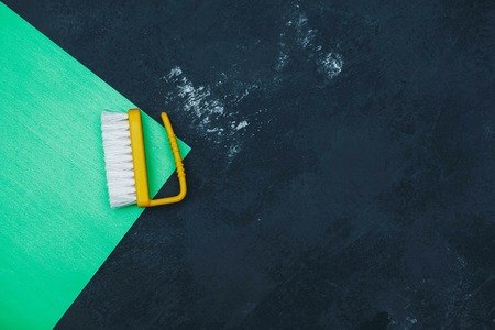 Tidying up a house, office or hotel with yellow plastic clothes brush. Bright composition of...