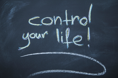 Motivate yourself. Control your life inscription on a blackboard written with colored chalks.の写真素材