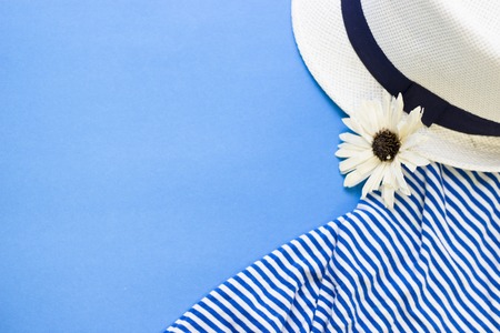 Travel and tourism concept. Blue one-color background with beach clothing items, top view. Space for a text or product display.の写真素材