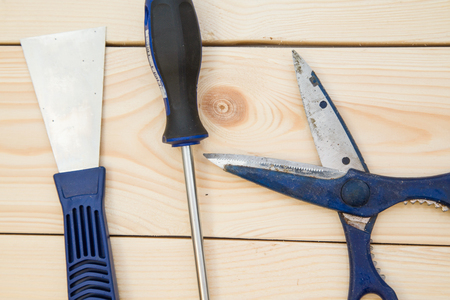 Repairing and construction concept. A set of tools for house repair-a plastering trowel, scissors and screwdriver on a light uncolored wooden background, close up. Top view. Space for your text or pruduct display.の写真素材
