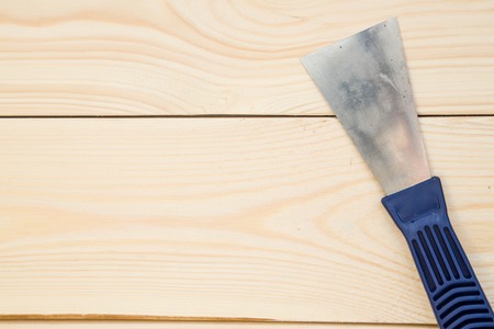 Repairing and construction concept. A close up of a plastering trowel on a light uncolored wooden background. Top view. Space for your text or pruduct display.の写真素材